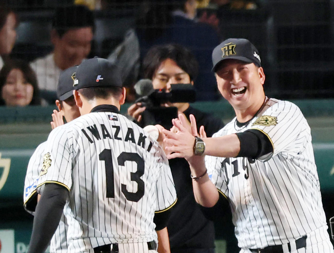 ナインを笑顔で迎える阪神藤川監督（右）（撮影・加藤哉）