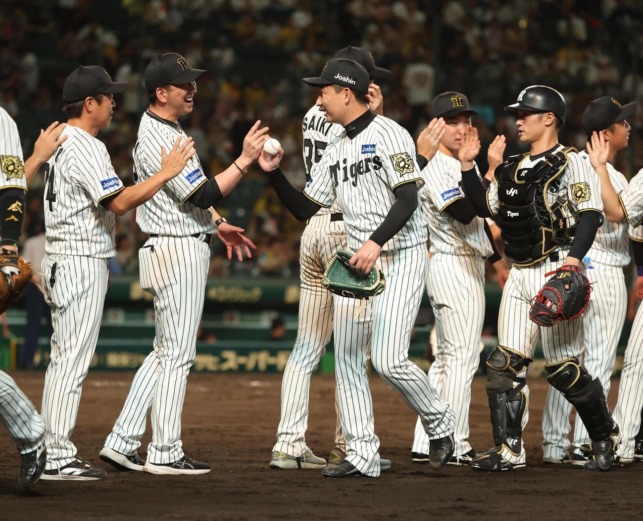 阪神対巨人　藤川監督（左から2人目）は試合を締めた岩崎をハイタッチで出迎える（撮影・上田博志）
