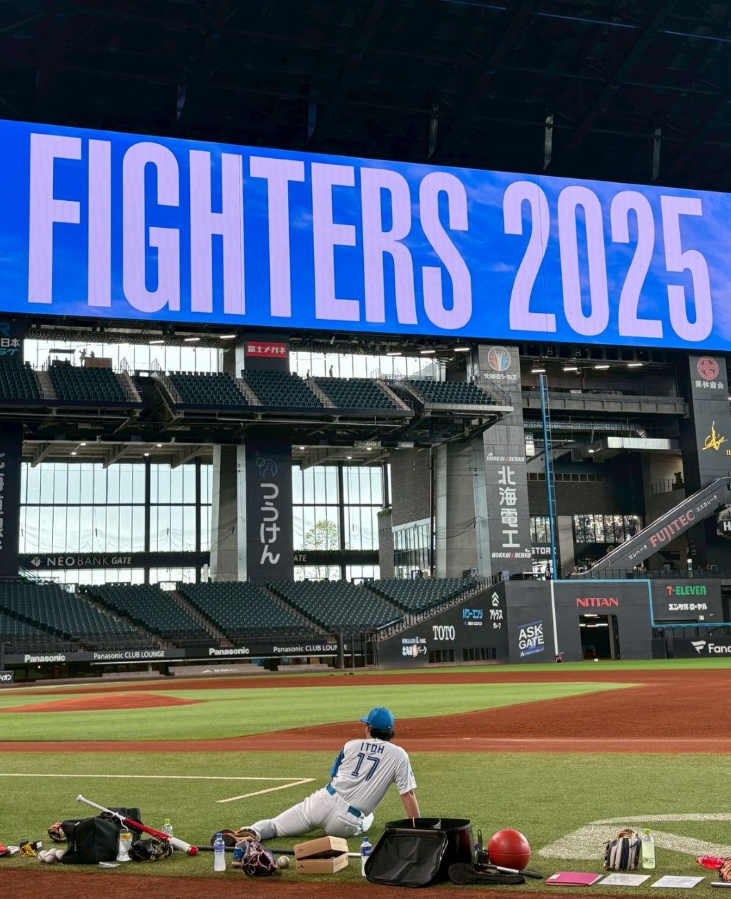 「FIGHTERS 2005」と映し出される大型ビジョンの前でストレッチする日本ハム伊藤