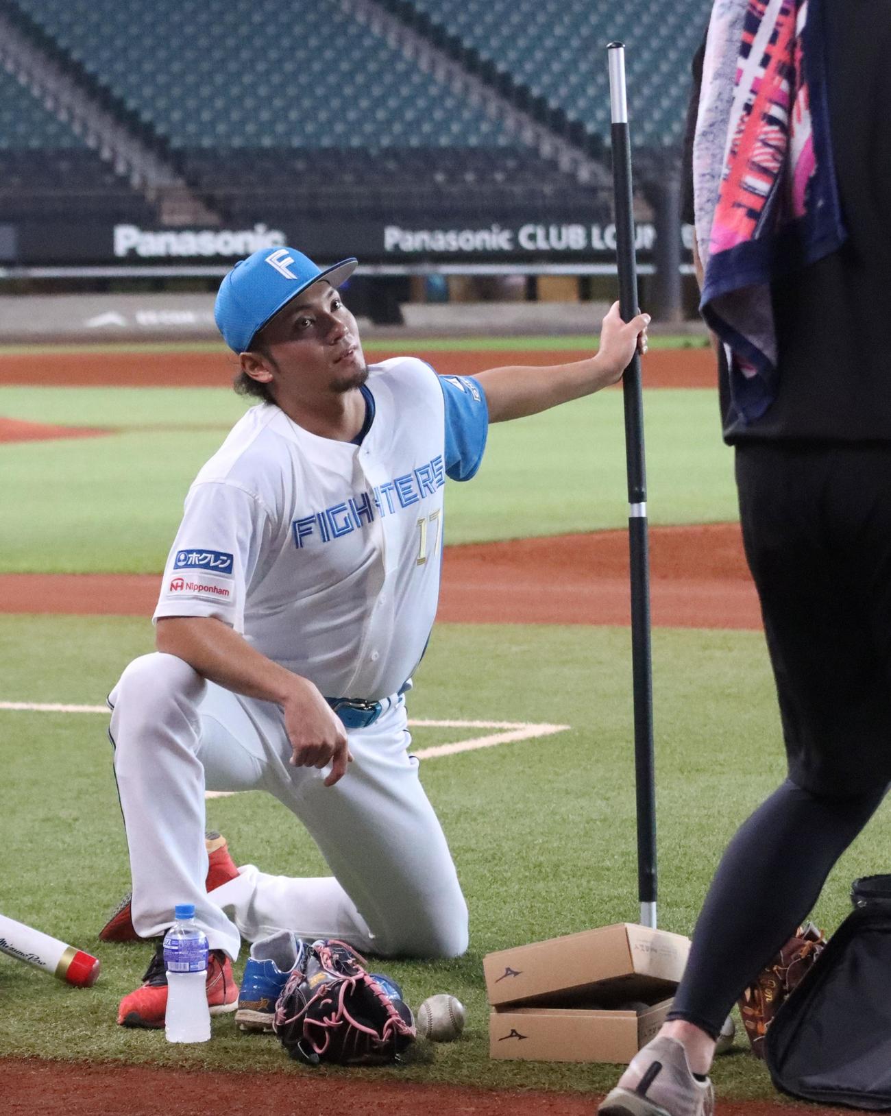 トレーニング用の長い棒を持つ日本ハム伊藤