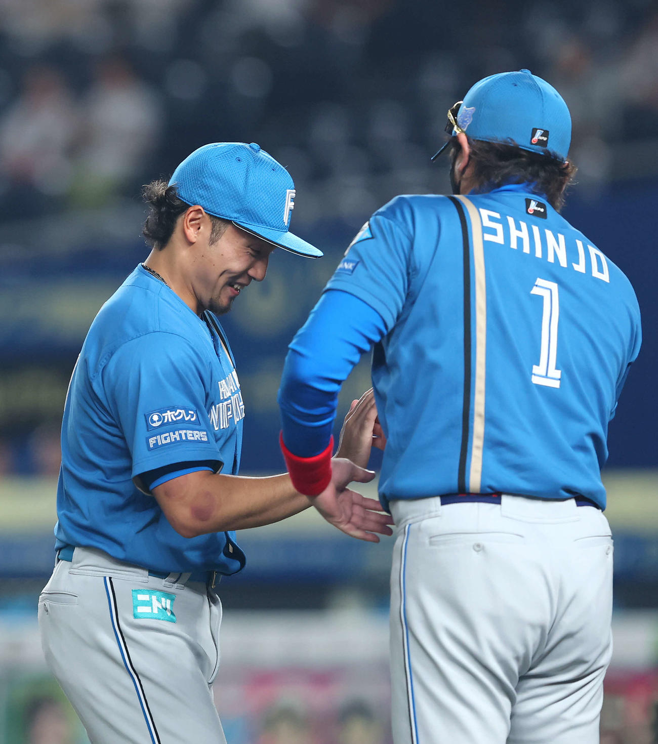 ロッテ対日本ハム　ロッテに勝利し、タッチを交わす日本ハム伊藤（左）と新庄監督（撮影・河田真司）
