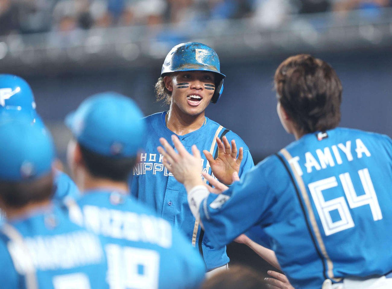 ロッテ対日本ハム　3回表日本ハム1死二、三塁、レイエスの中前適時打で生還し、チームメートに迎えられる水谷（撮影・河田真司）
