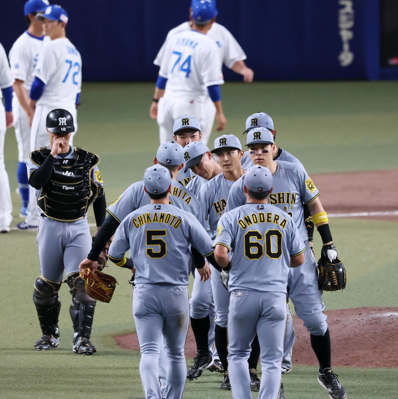 中日対阪神　中日に勝利しマウンド付近でタッチする熊谷ら阪神ナイン（撮影・加藤哉）