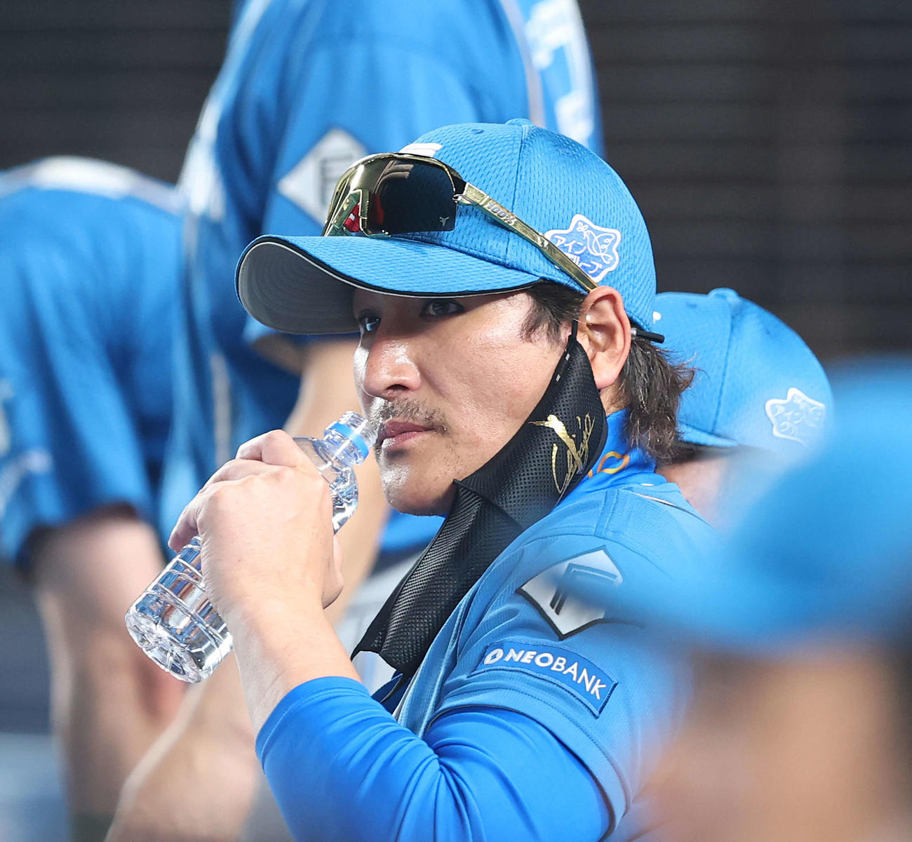 ロッテ対日本ハム　4回表を終え、選手交代を告げ、ベンチに戻り水分補給する新庄監督（撮影・河田真司）