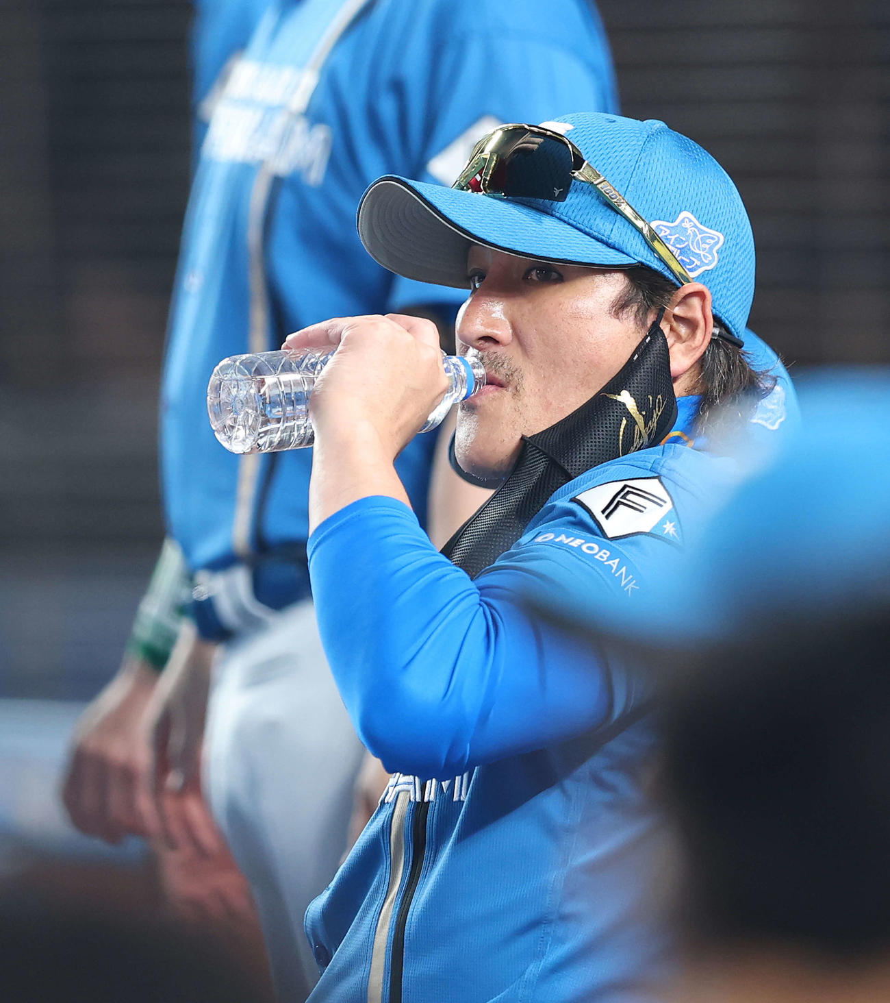 ロッテ対日本ハム　4回表を終え、選手交代を告げ、ベンチに戻り水分補給する新庄監督（撮影・河田真司）