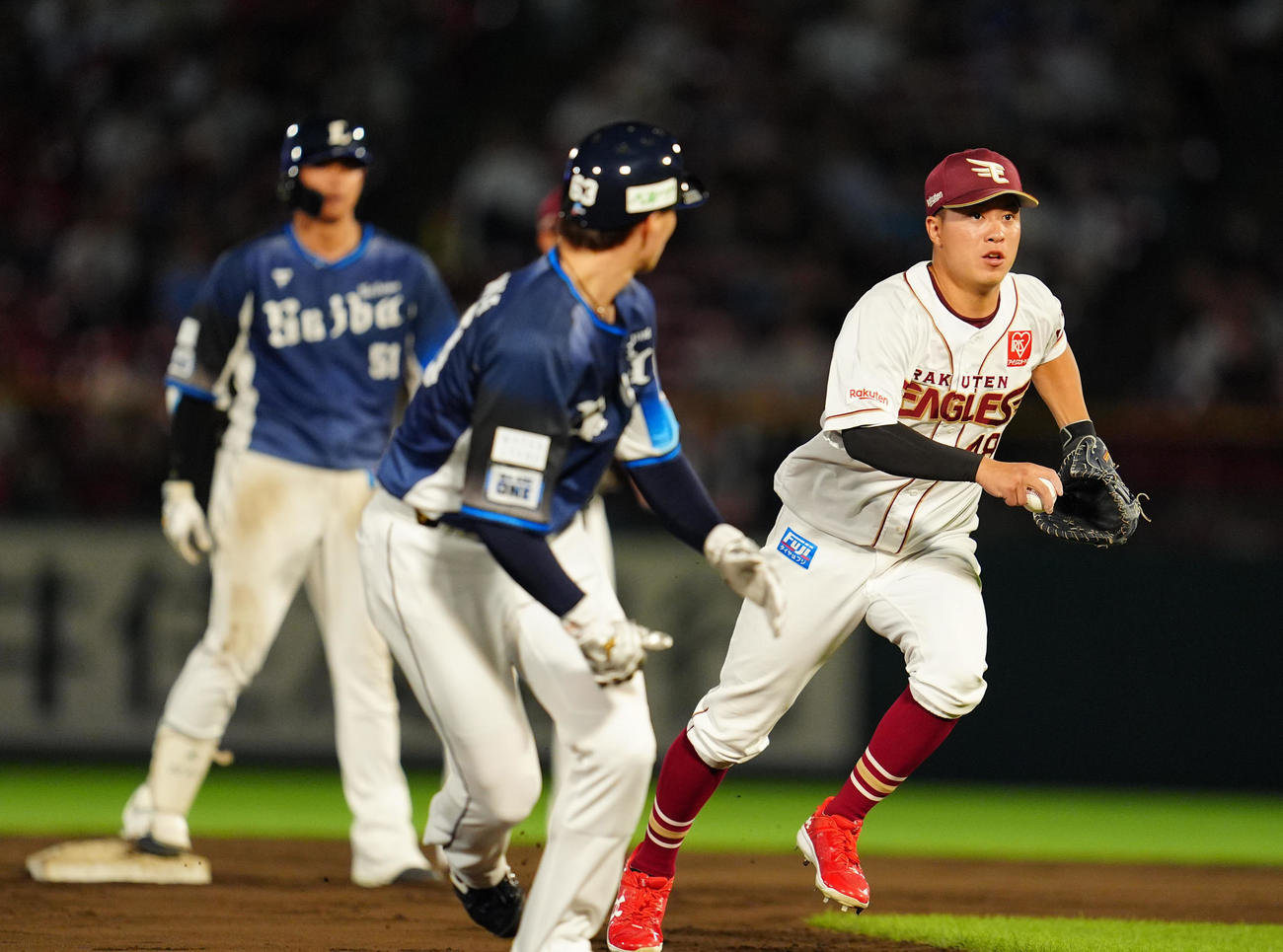 楽天対西武　6回表西武1死二、三塁、それを見て三塁走者古賀悠が本塁へ突入、一塁手渡辺佳（右）が本塁へ送球もそれてしまい（撮影・清水貴仁）