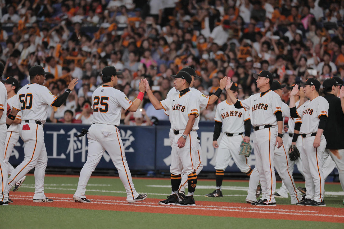 巨人対ヤクルト　両手に赤いサポーターを巻いた岡本（左から2人目）とハイタッチする阿部監督（中央）ら（撮影・宮崎幸一）