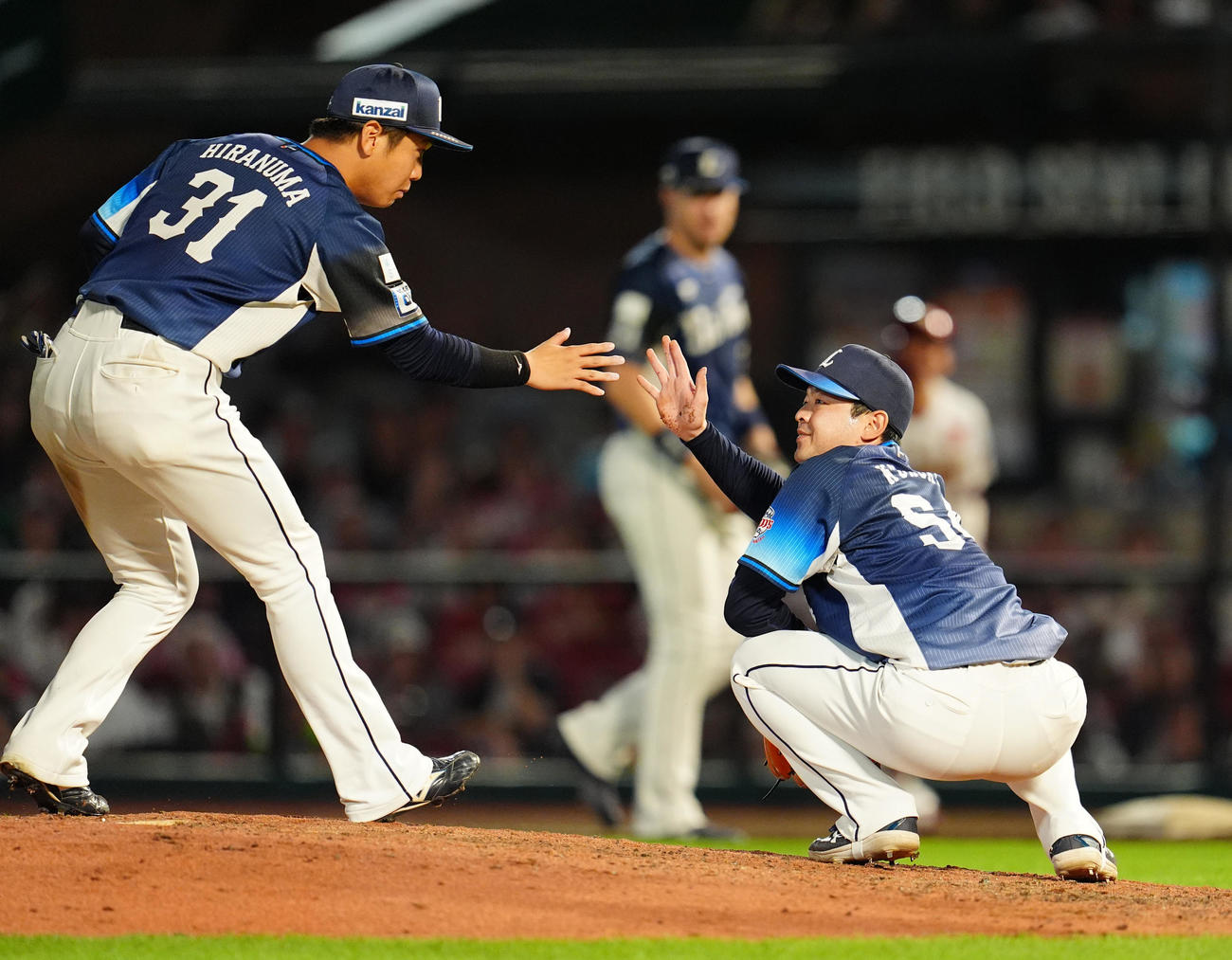 楽天対西武　7回裏楽天2死一塁、宗山を三ゴロに打ち取った黒木（右）は平沼とタッチを交わす（撮影・清水貴仁）
