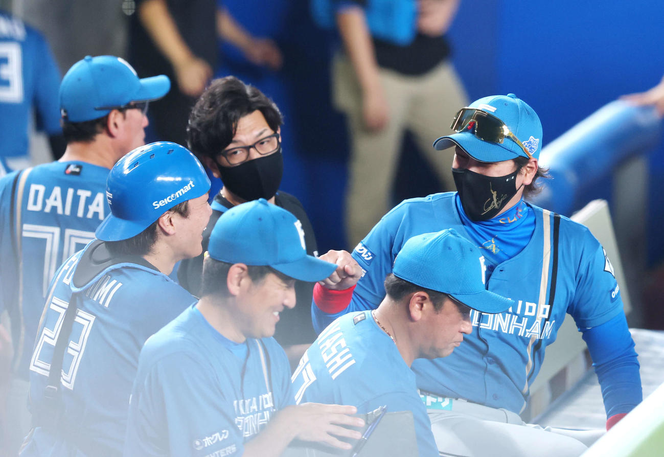 ロッテ対日本ハム　1回裏を終え、伏見（左）と言葉を交わす新庄監督（撮影・河田真司）