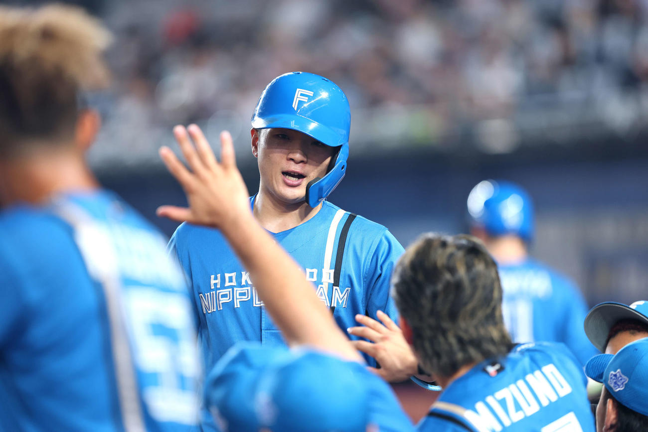 ロッテ対日本ハム　2回表日本ハム1死、左越え先制ソロ本塁打で生還し、チームメートに迎えられる郡司（撮影・河田真司）