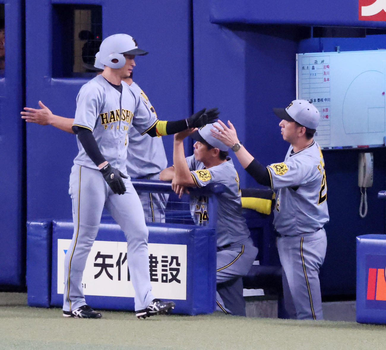 中日対阪神　7回表阪神1死二、三塁、森下の中越え2点適時二塁打で生還した二塁走者近本（左）はベンチの藤川監督とタッチする（撮影・加藤哉）