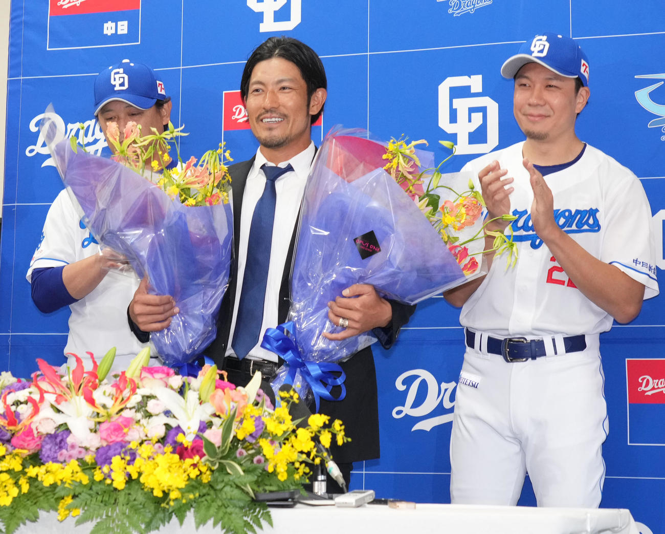 会見後、花束を手に笑顔を見せる祖父江（中央）（撮影・森本幸一）