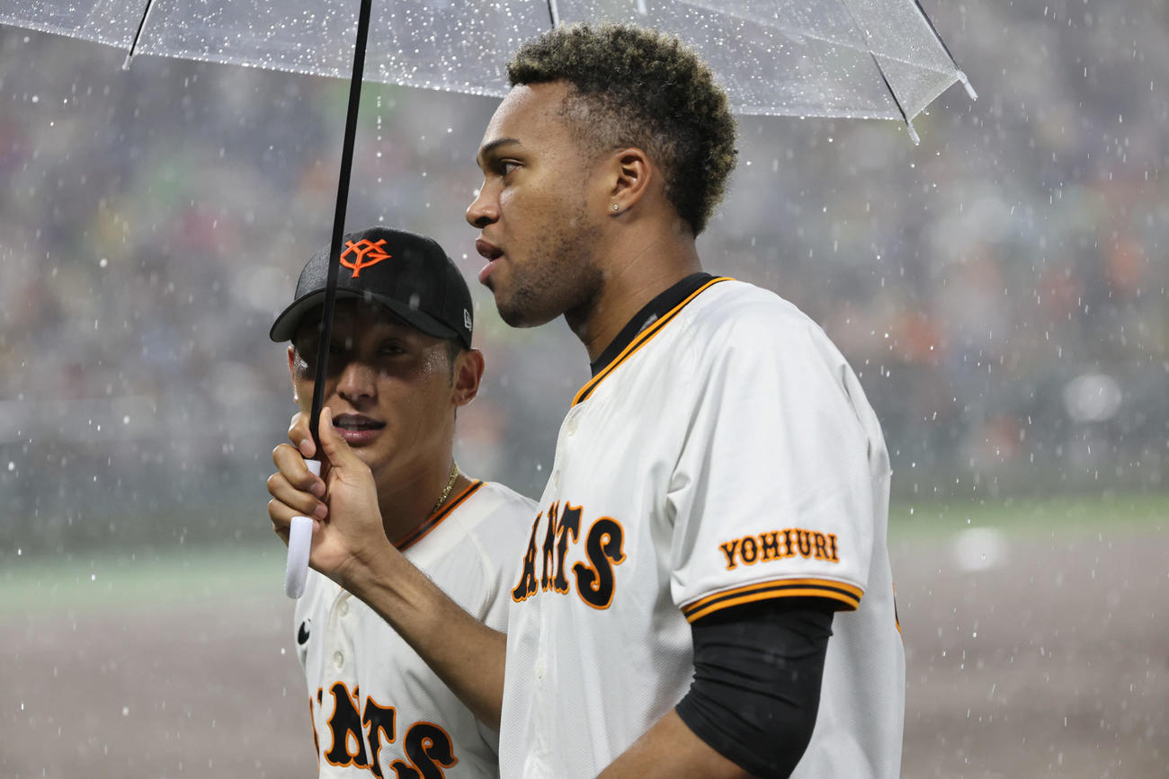 4日、巨人対ヤクルト　激しい雨が降り試合が中断。屋根のないブルペンにいたライデル・マルティネスはかさをさしてベンチに戻る