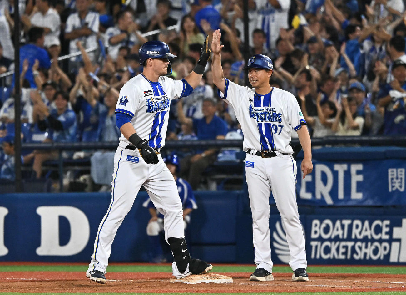 DeNA対ヤクルト　6回裏DeNA2死一、二塁、代打オースティン（左）は中前2点適時打を放ち田中コーチとタッチを交わす（撮影・滝沢徹郎）