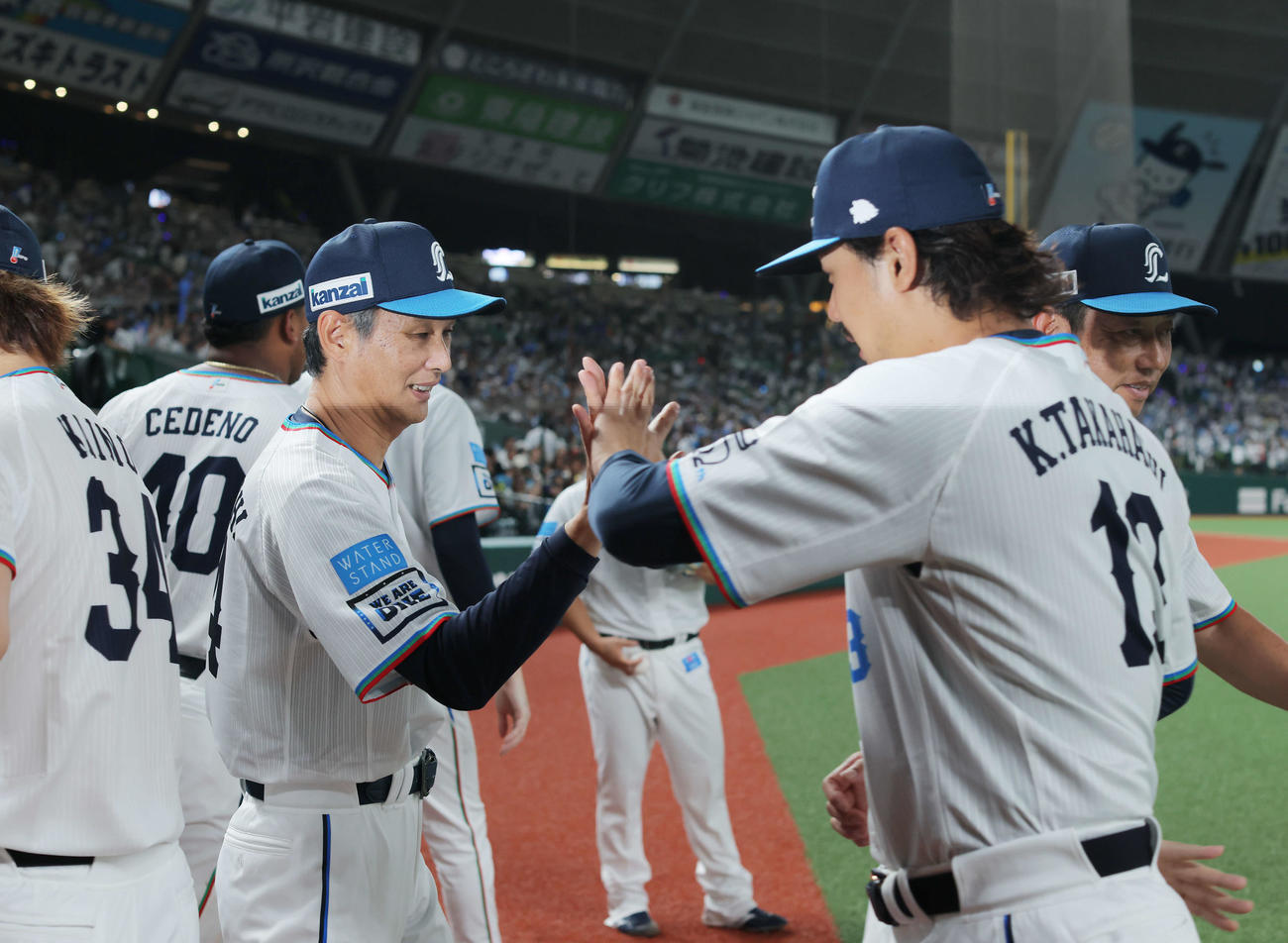 西武対ロッテ　ロッテに勝利し、高橋（右）らナインを迎える西口監督（撮影・河田真司）