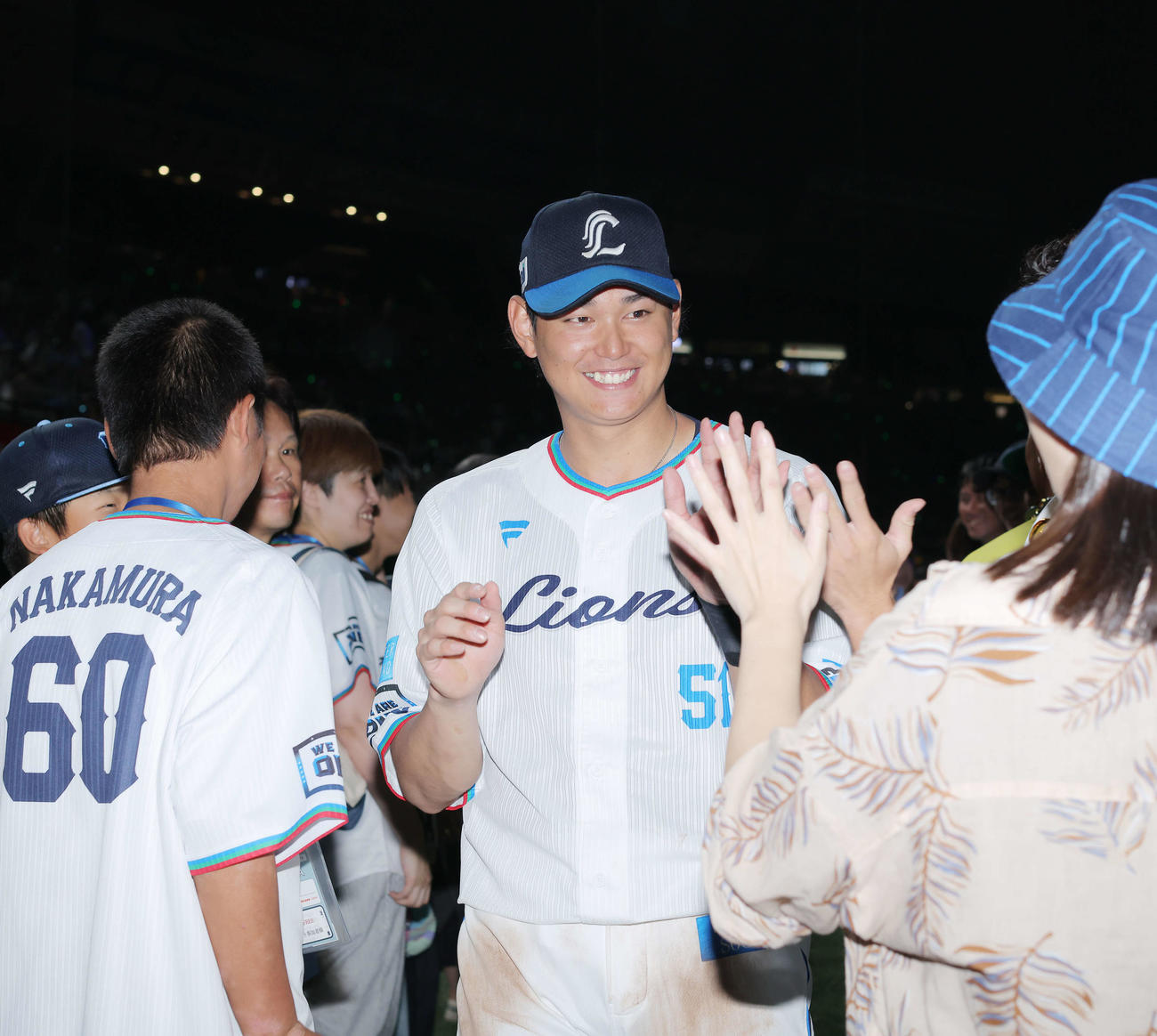 西武対ロッテ　ロッテに勝利し、ファンとタッチを交わす西武西川（撮影・河田真司）