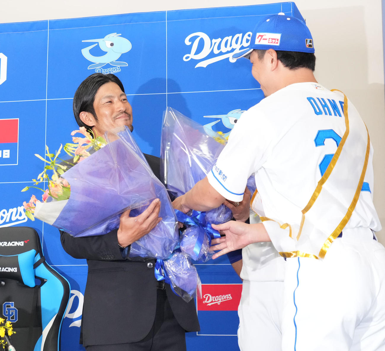 会見後、祖父江（左）は大野から花束を受け取る（撮影・森本幸一）