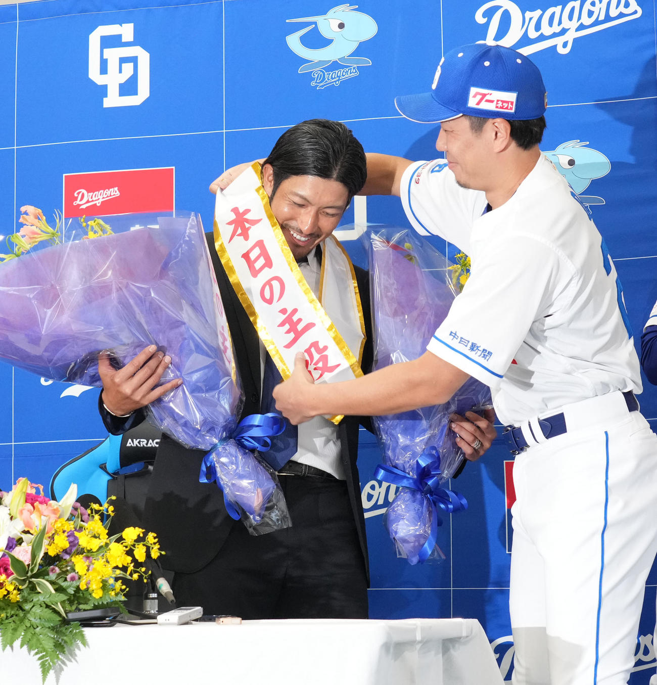 会見後、祖父江（左）は大野からたすきを掛けられる（撮影・森本幸一）