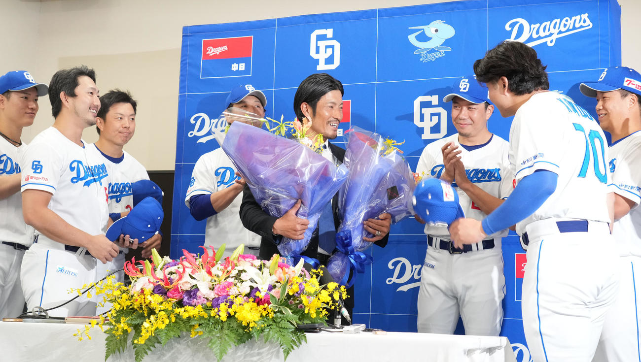 会見後、花束を手に笑顔を見せる祖父江（左から5人目）（撮影・森本幸一）