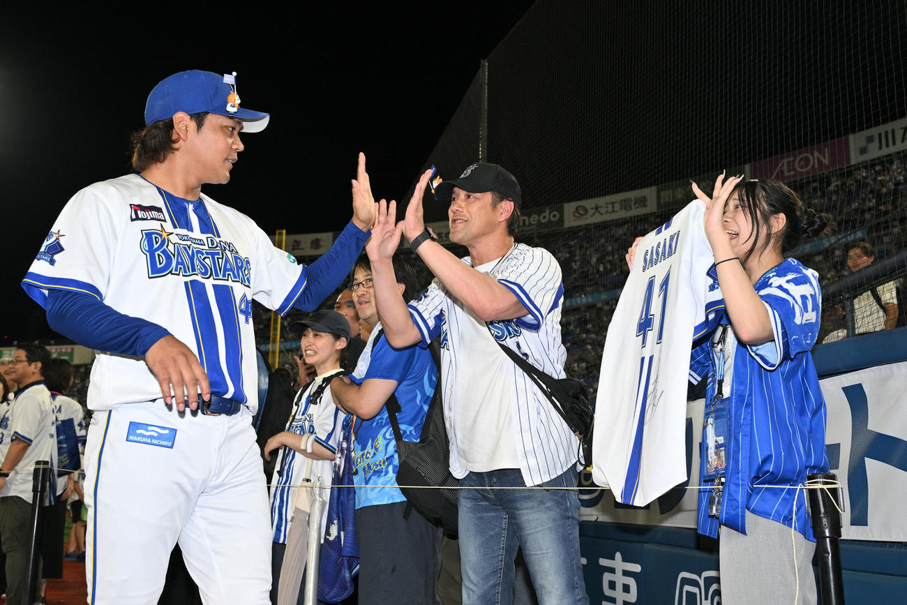 DeNA対ヤクルト　試合後、勝利投手のDeNA佐々木はファンとタッチを交わす（撮影・滝沢徹郎）