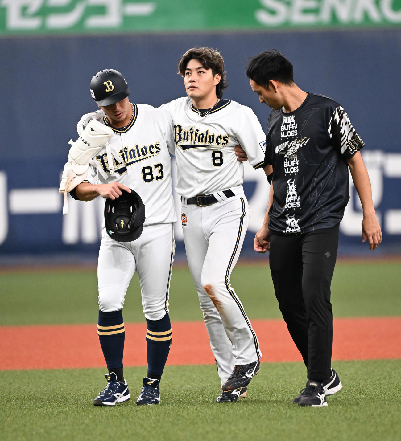 オリックス対日本ハム　3回裏オリックス2死、右中間に二塁打を放ち滑り込んだ麦谷祐介は膝を痛め、一時安達コーチ（左）の肩を借りて治療する（撮影・和賀正仁）