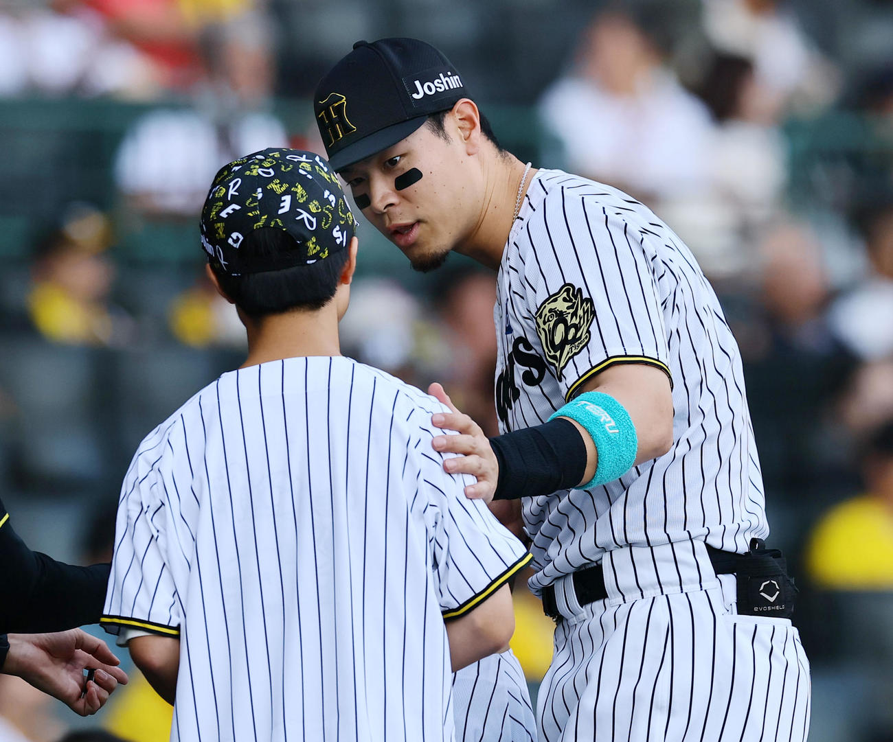 阪神対広島　ファーストピッチセレモニーを終え前田悠真さんと言葉を交わす阪神佐藤輝（撮影・藤尾明華）