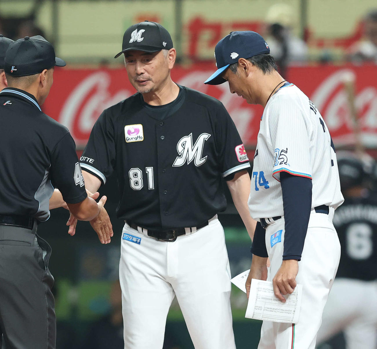 西武対ロッテ　開始前、審判と握手を交わすロッテ吉井監督（左）と西武西口監督（撮影・河田真司）