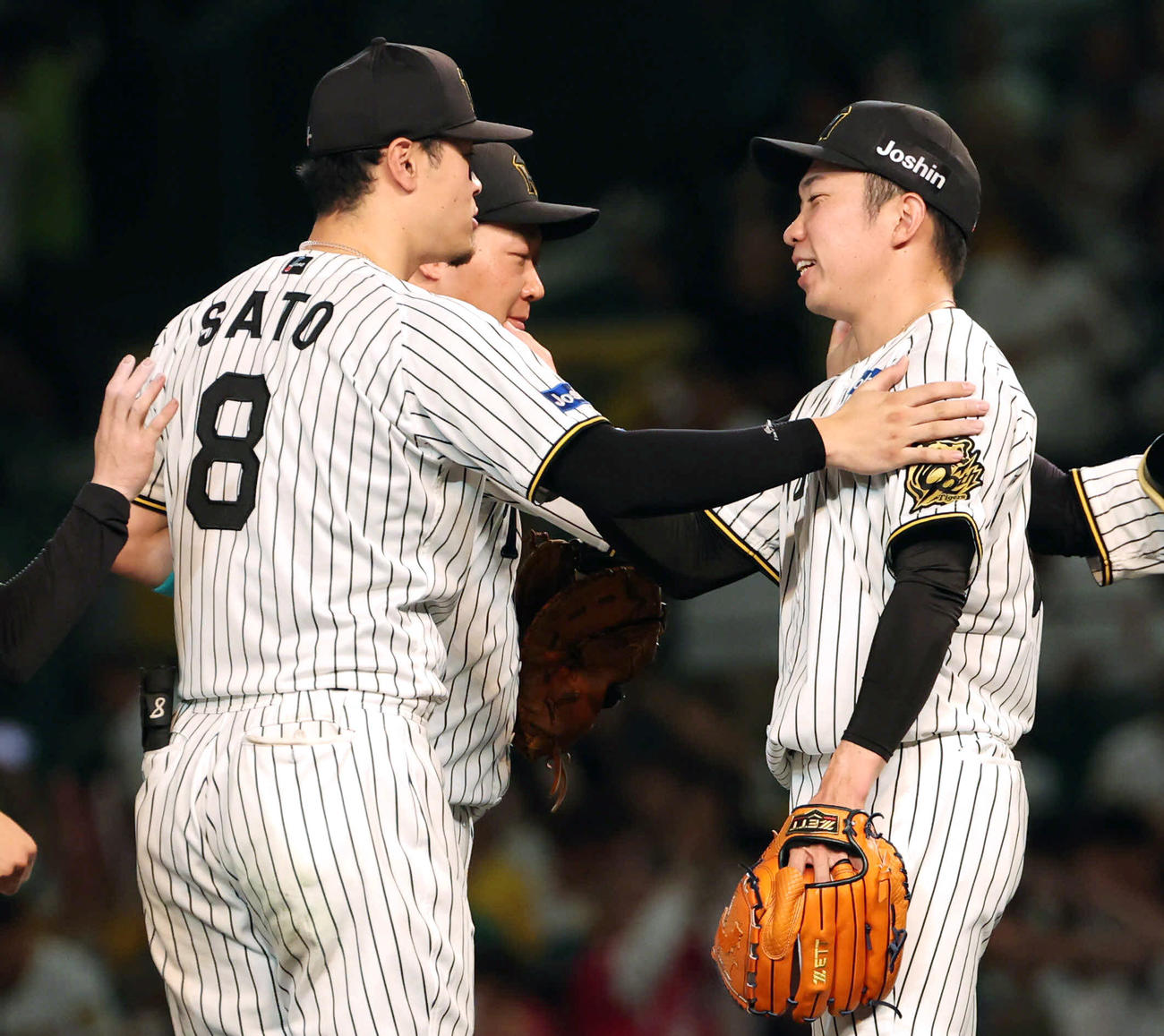 阪神対広島　最後を締めた阪神石井（右）は佐藤輝（手前）、大山にねぎらわれる（撮影・西尾就之）
