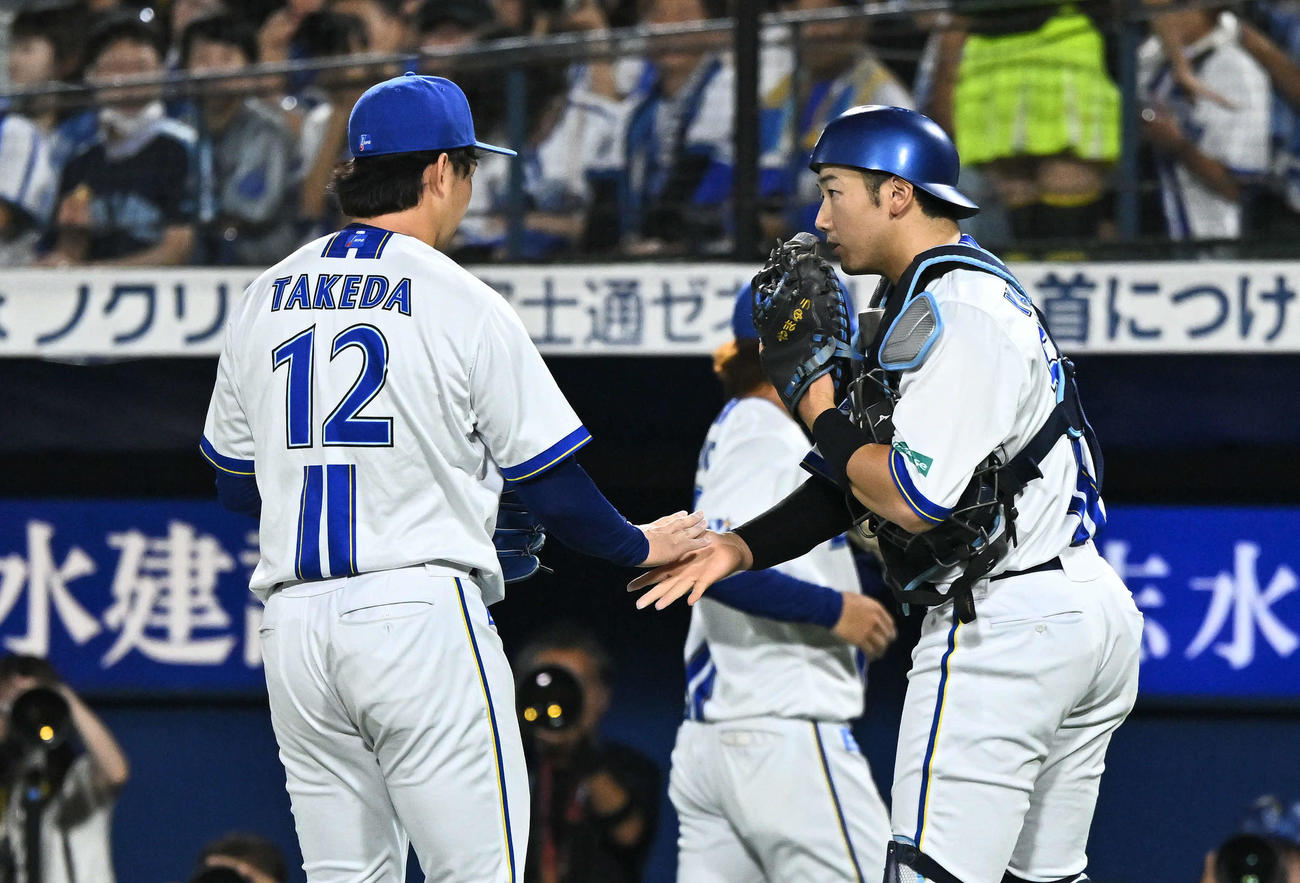 DeNA対ヤクルト　2回表を投げ終えたDeNA先発の竹田（左）は山本とタッチを交わす（撮影・滝沢徹郎）