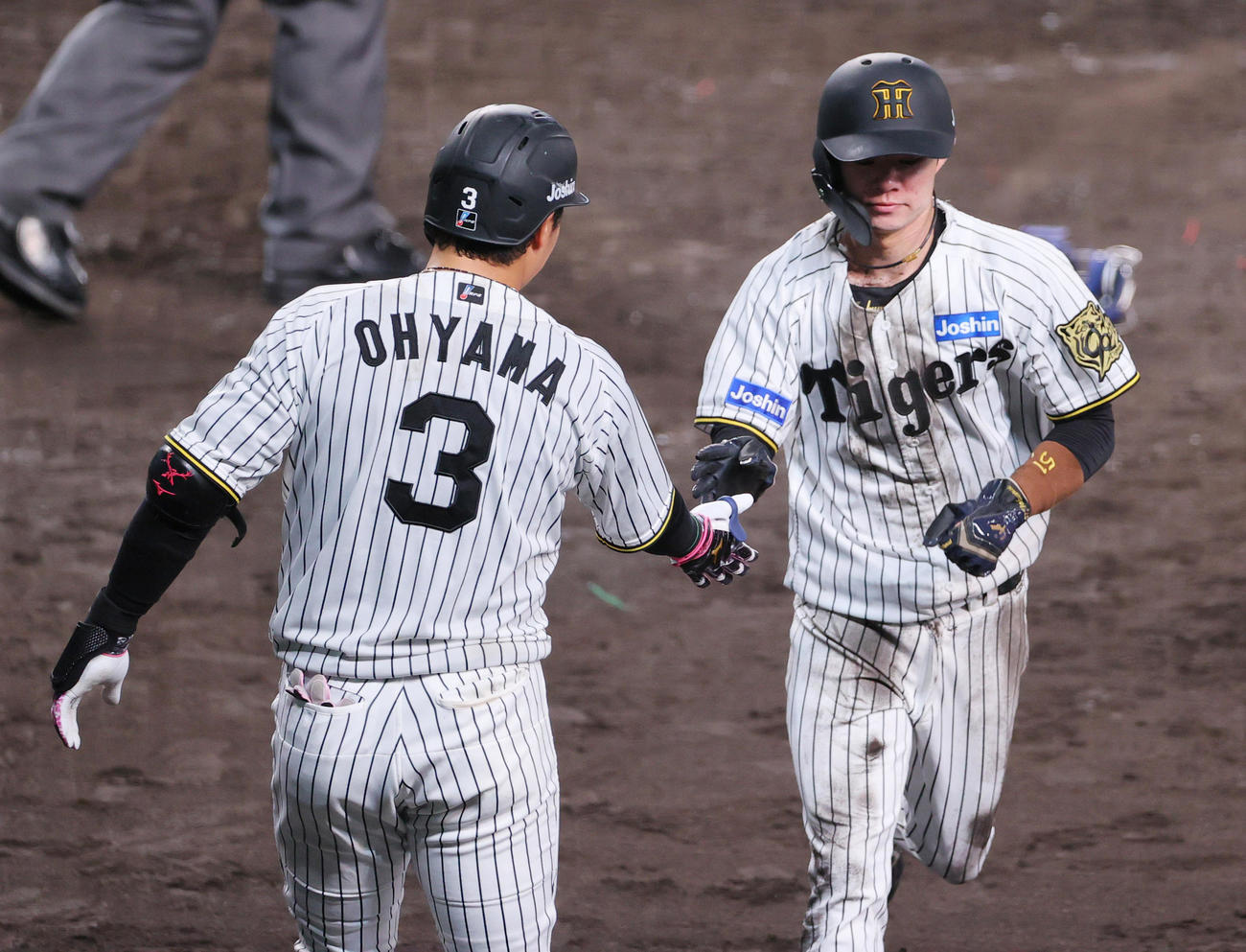 阪神対広島　4回裏阪神1死一、二塁、佐藤輝の右前適時打で生還した二走中野（右）は大山とタッチをかわす（撮影・上山淳一）