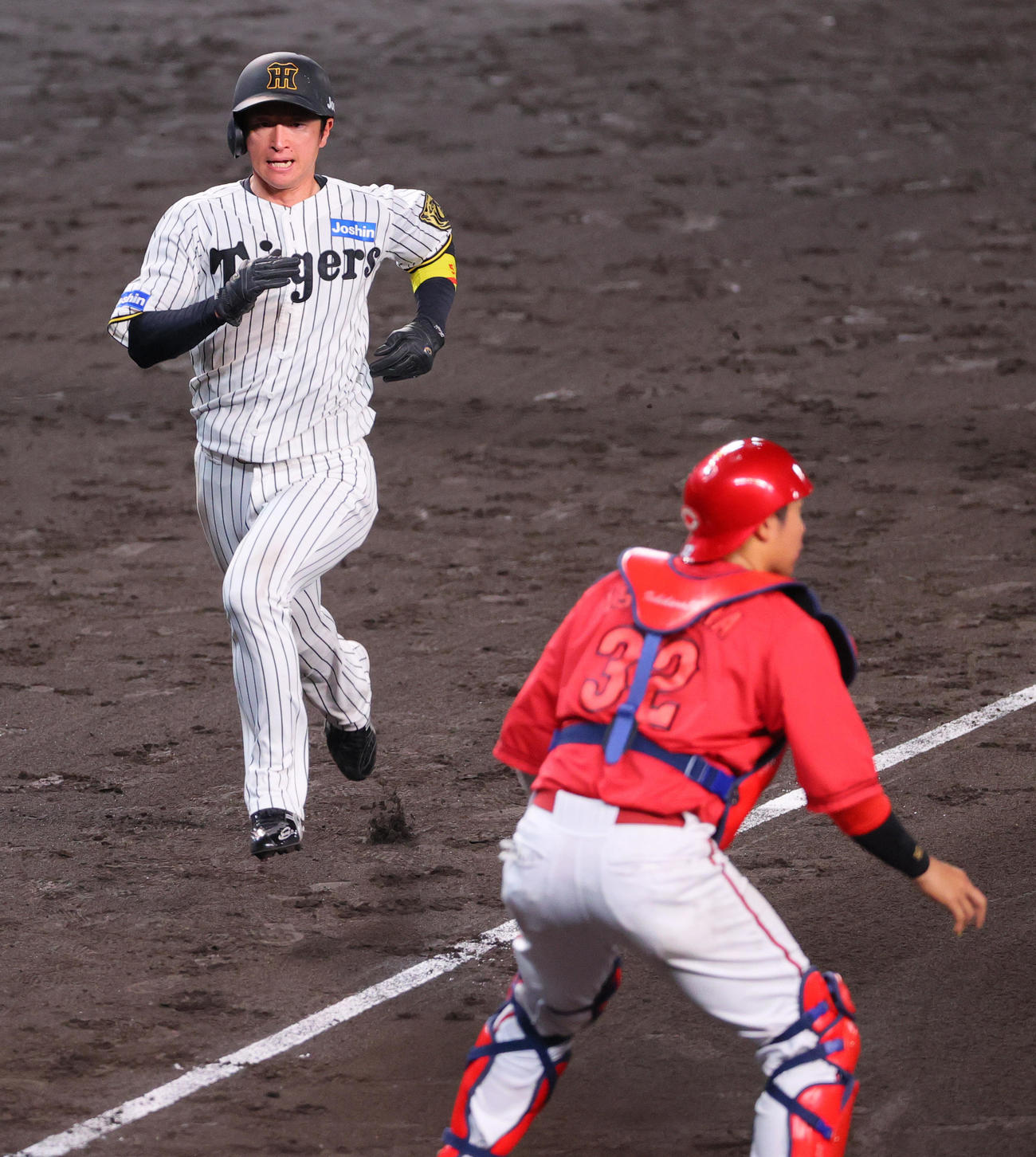 阪神対広島　7回裏阪神1死二塁、二走近本（左）は中野の中前適時打で生還する、捕手石原（撮影・上山淳一）
