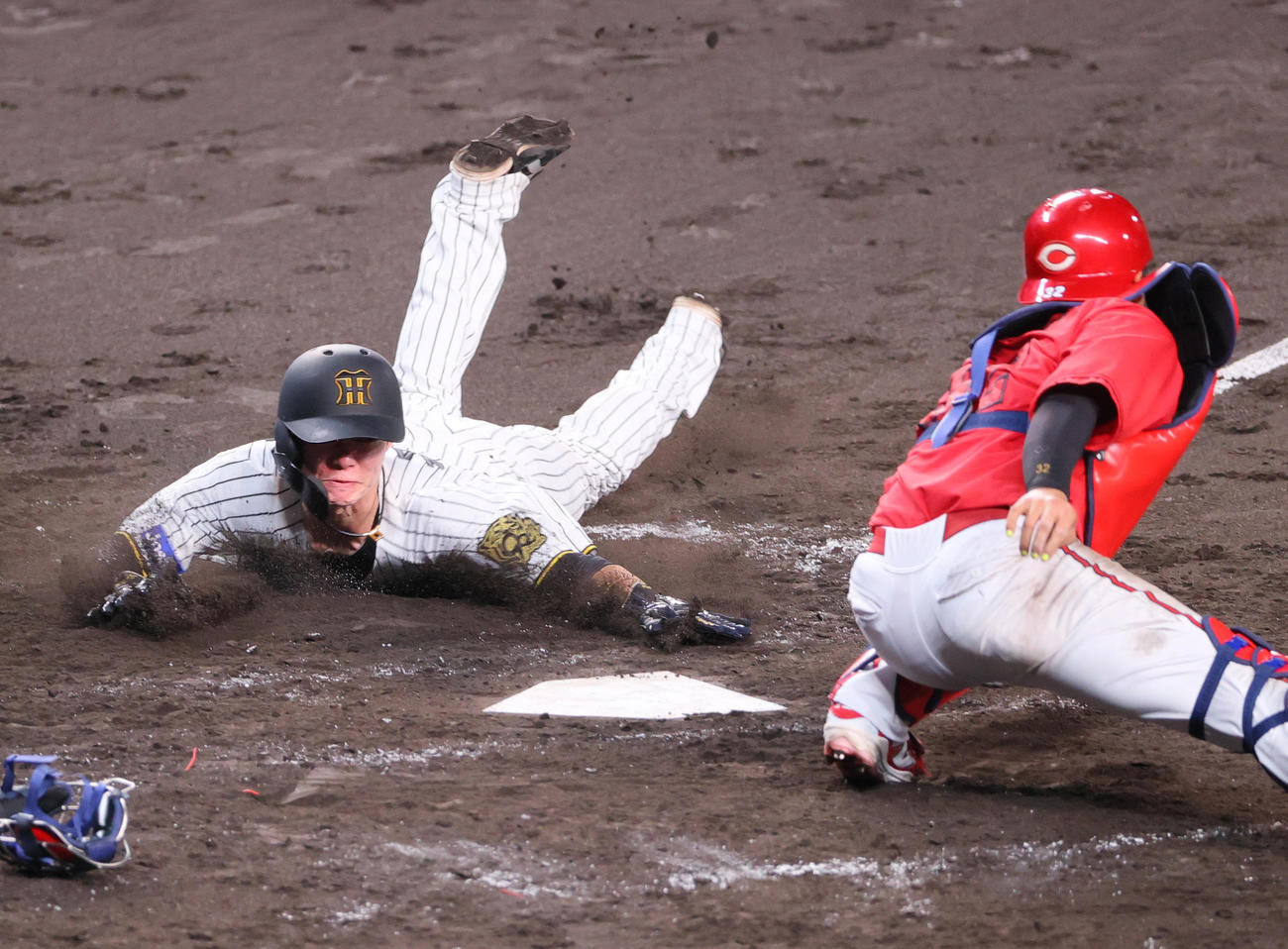 阪神対広島　4回裏阪神1死一、二塁、二走中野（左）は佐藤輝の右前適時打で生還する。捕手石原（撮影・上山淳一）