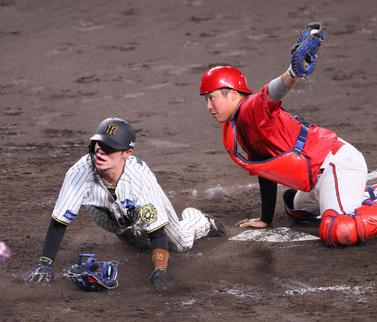 阪神対広島　4回裏阪神1死一、二塁、二走中野（左）は佐藤の右前適時打で生還する。捕手石原（撮影・上山淳一）