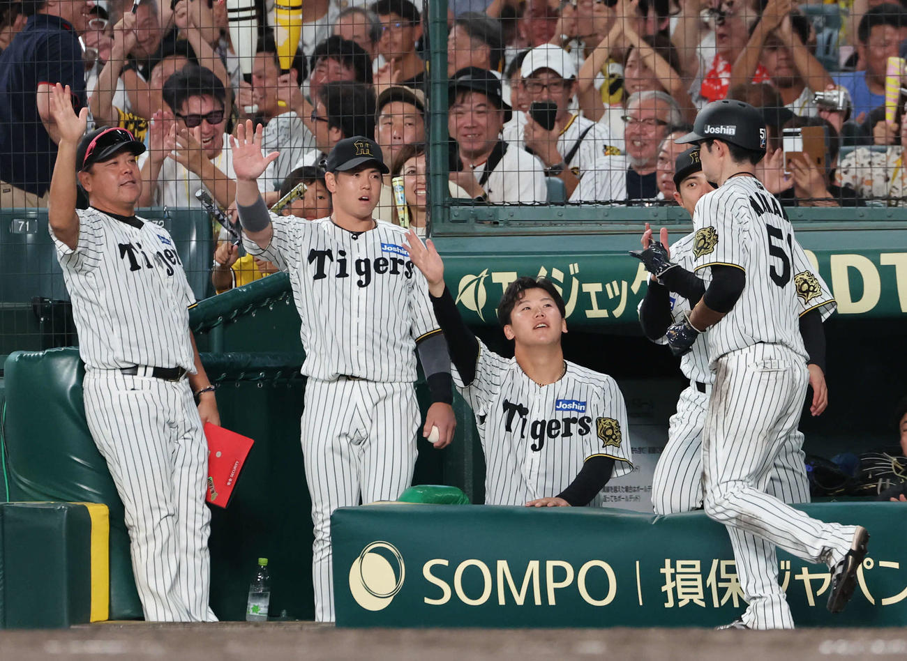 阪神対広島　4回裏阪神1死一、二塁、二走中野（右）は佐藤輝の適時打で生還し先発の門別（左から3人目）らの出迎えを受ける（撮影・西尾就之）