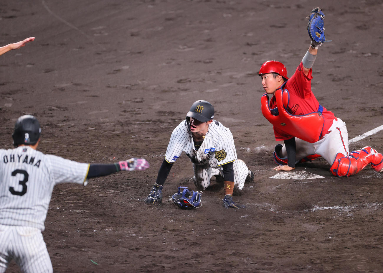 阪神対広島　4回裏阪神1死一、二塁、二走中野（中央）は佐藤の右前適時打で生還する。捕手石原（撮影・上山淳一）