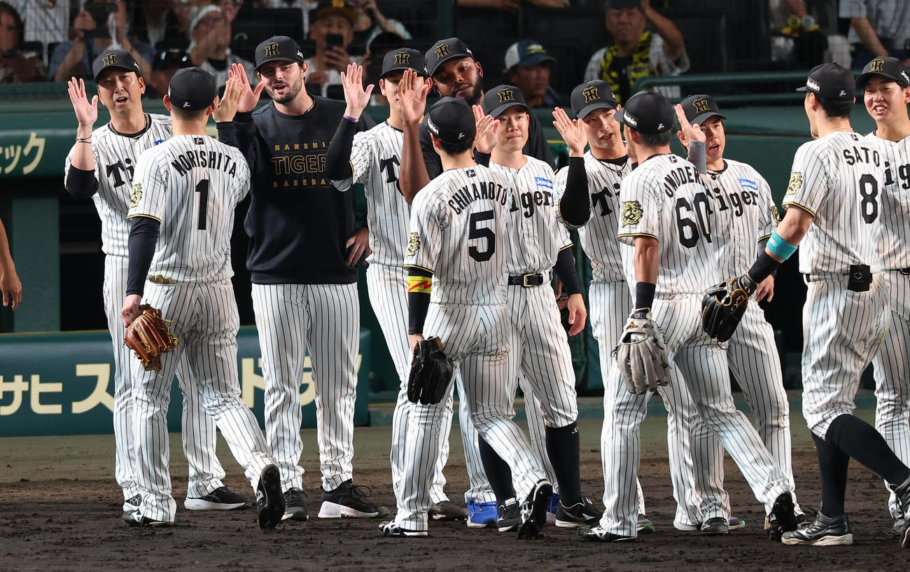 阪神対広島　広島に勝利した藤川監督（左）は勝ち越し適時打を放った森下（左から2人目）らナインとハイタッチをする（撮影・上田博志）