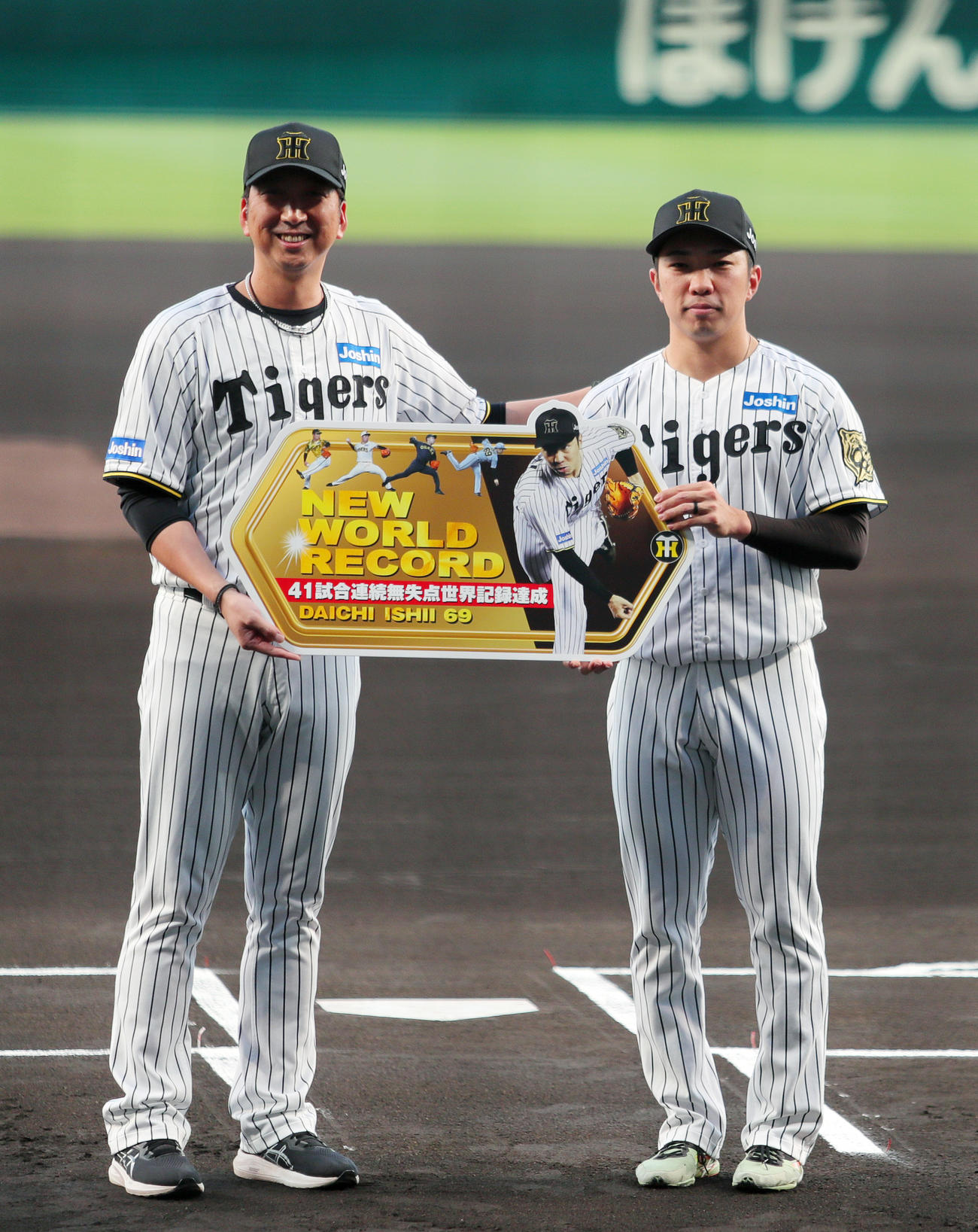 阪神対広島　41試合連続無失点記録を達成した阪神石井（右）は藤川監督と記念撮影する（撮影・上山淳一）