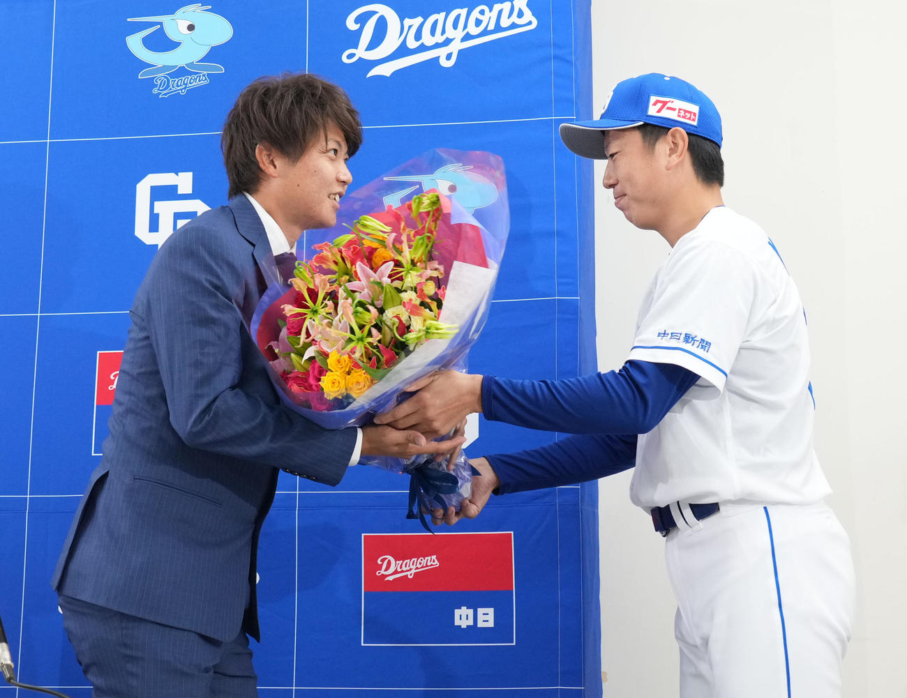 会見後、岡田（左）は松葉から花束を受け取る（撮影・森本幸一）
