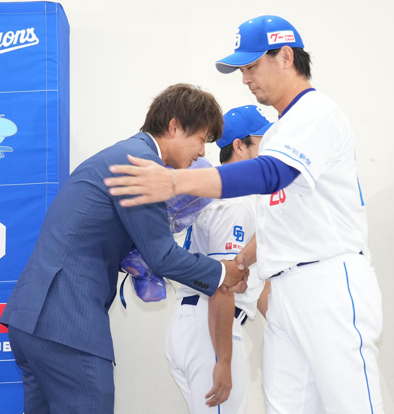 会見後、岡田（左）は涌井と握手を交わす（撮影・森本幸一）