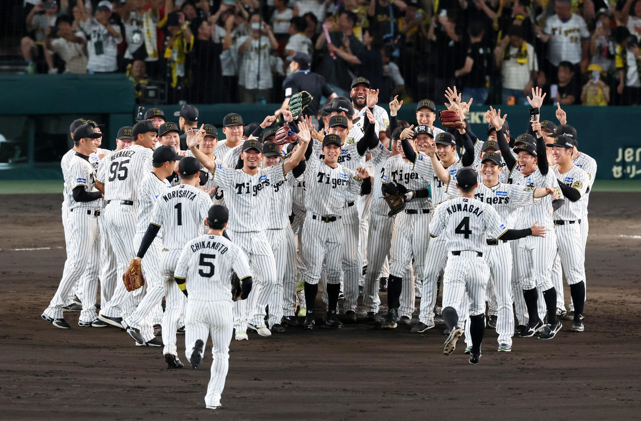 阪神対広島　リーグ優勝を決め外野陣を迎えるマウンドの歓喜の輪を作る阪神ナイン（撮影・加藤哉）