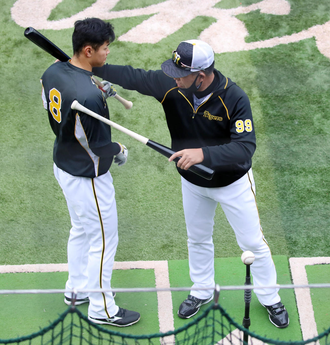佐藤輝明（左）にアドバイスする井上一樹ヘッドコーチ＝21年4月
