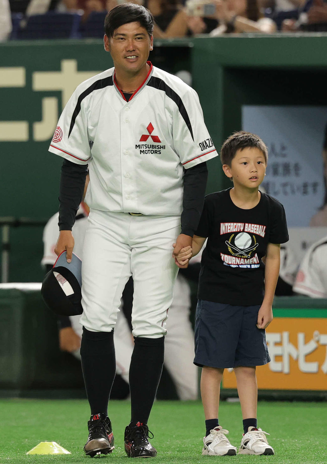 三菱自動車岡崎対日本生命　選手紹介でキッズサポーターと笑顔で登場する三菱自動車岡崎先発の戸田（左）（撮影・野上伸悟）