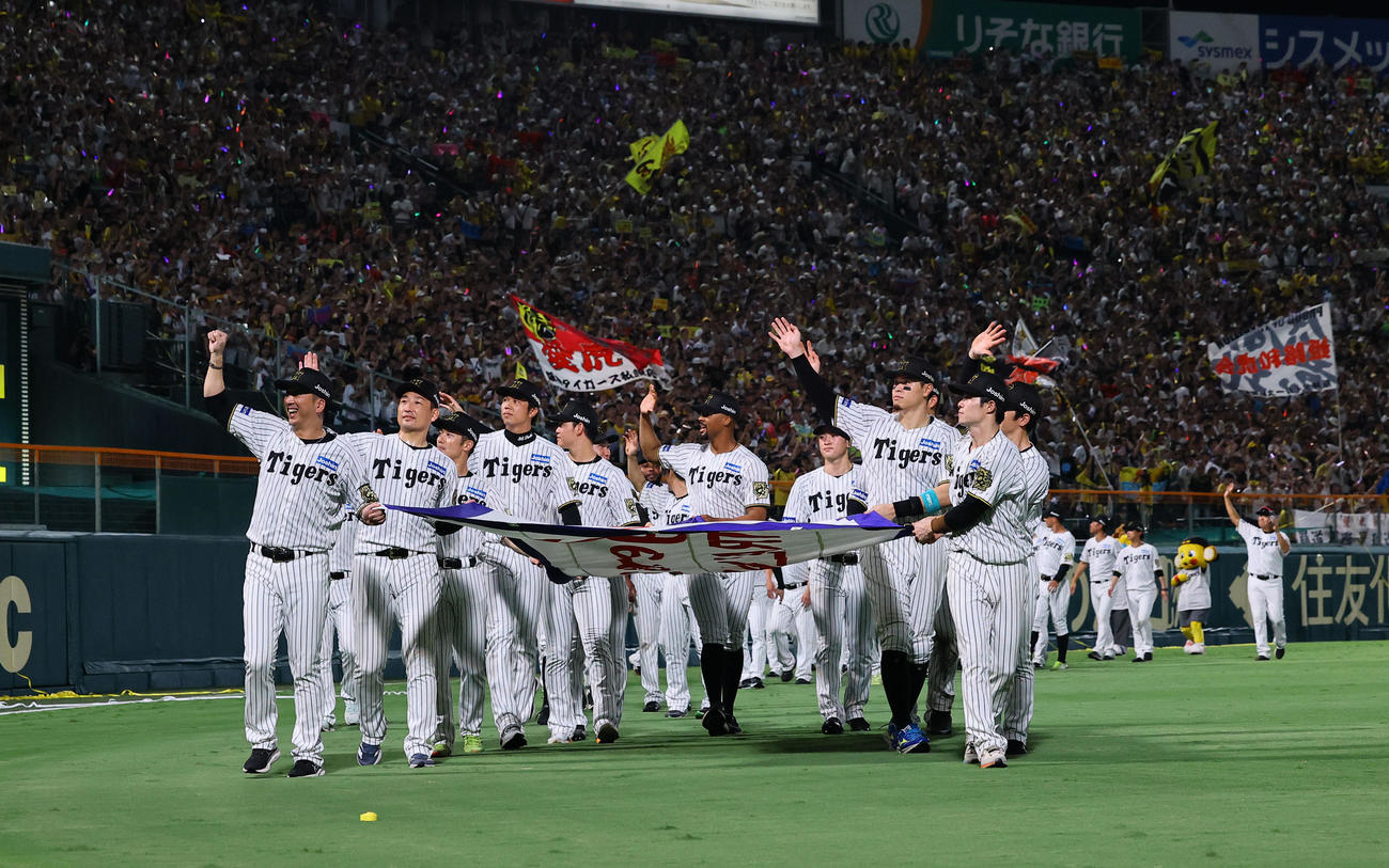 阪神対広島　優勝ペナントを手に場内1周する藤川監督（手前左）ら阪神ナイン（撮影・藤尾明華）