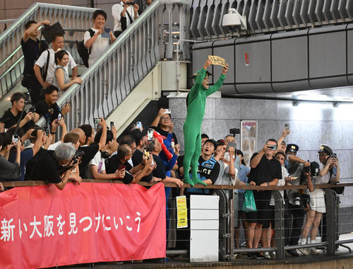 阪神のリーグ優勝に喜ぶも、「トビコムナ」と書かれたボードを持つカメの衣装を着たファン(撮影・和賀正仁)