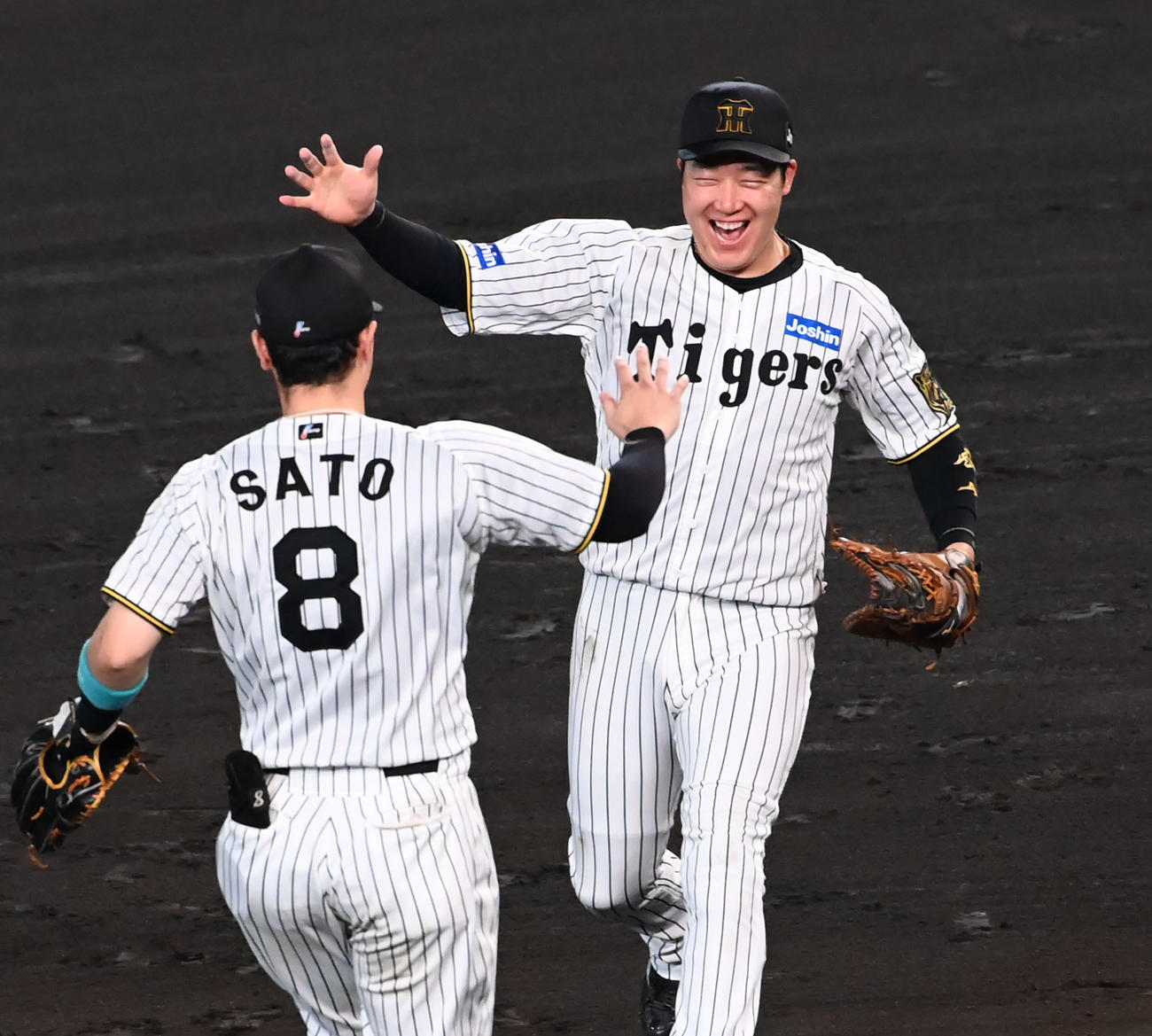 リーグ優勝を果たし佐藤輝（左）とハイタッチをする大山（撮影・石井愛子）