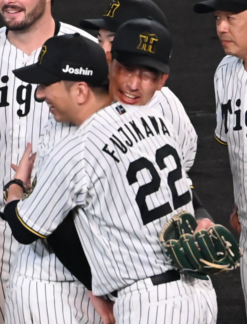 リーグ優勝を果たし抱き合う藤川監督（右）と岩崎（撮影・石井愛子）