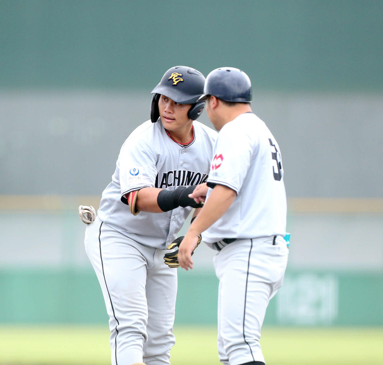 富士大対八戸学院大　8回裏八戸学院大1死満塁、右前適時打を放ち、グータッチを交わす八戸学院大・十鳥（左）（撮影・木村有優）