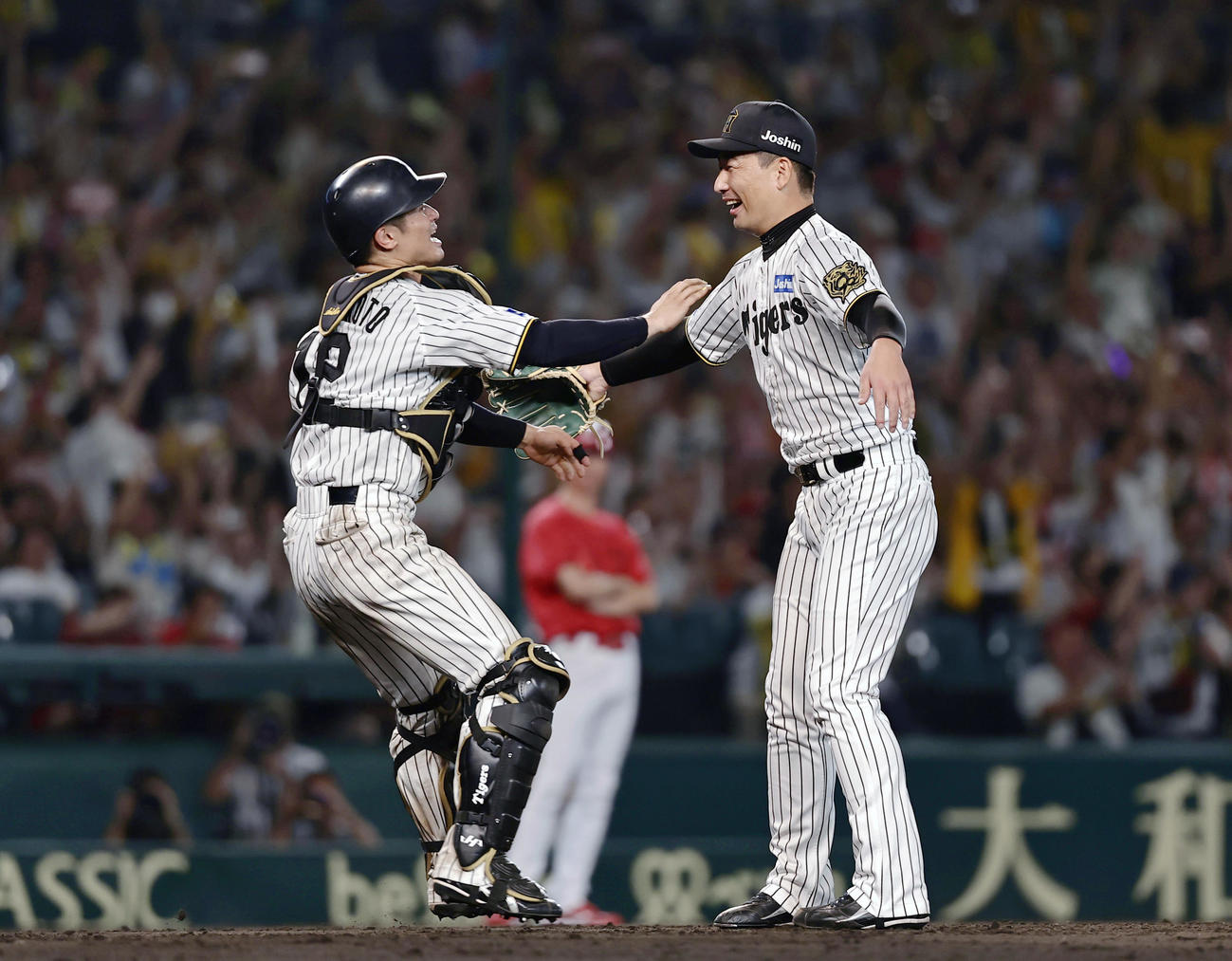リーグ優勝を決め、抱き合う阪神の岩崎（右）と坂本のバッテリー（共同）