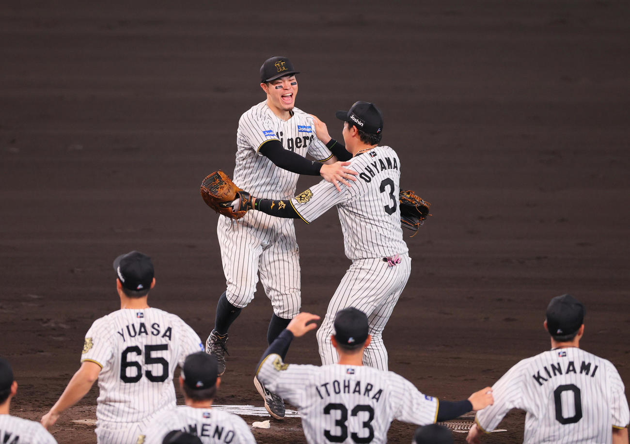 阪神対広島　セ・リーグ優勝を決めマウンドで抱き合う佐藤輝（左）と大山（撮影・上山淳一）