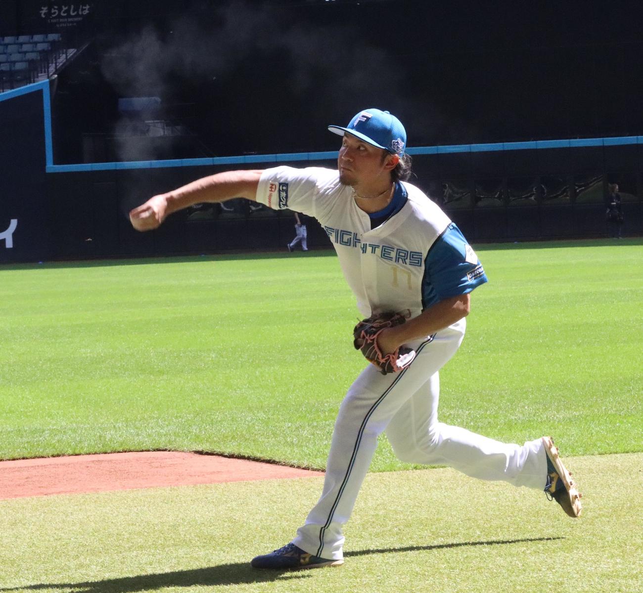 ロジンを振りまきながらキャッチボールする日本ハム伊藤